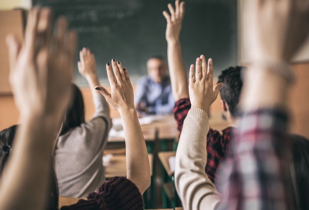 Engage - hands raised in classroom